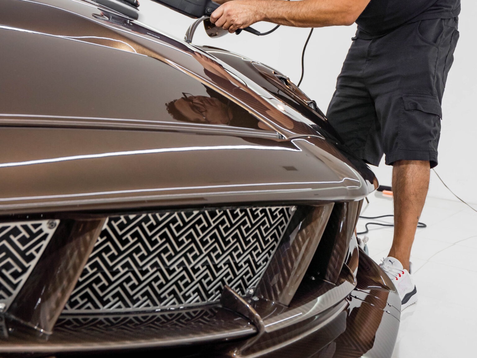A SoCal detailer machine-polishing a Pagani Huayra
